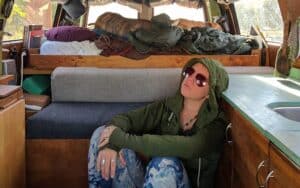 van life sitting on the floor inside a camper van looking dejected after making some huge vanlife mistakes
