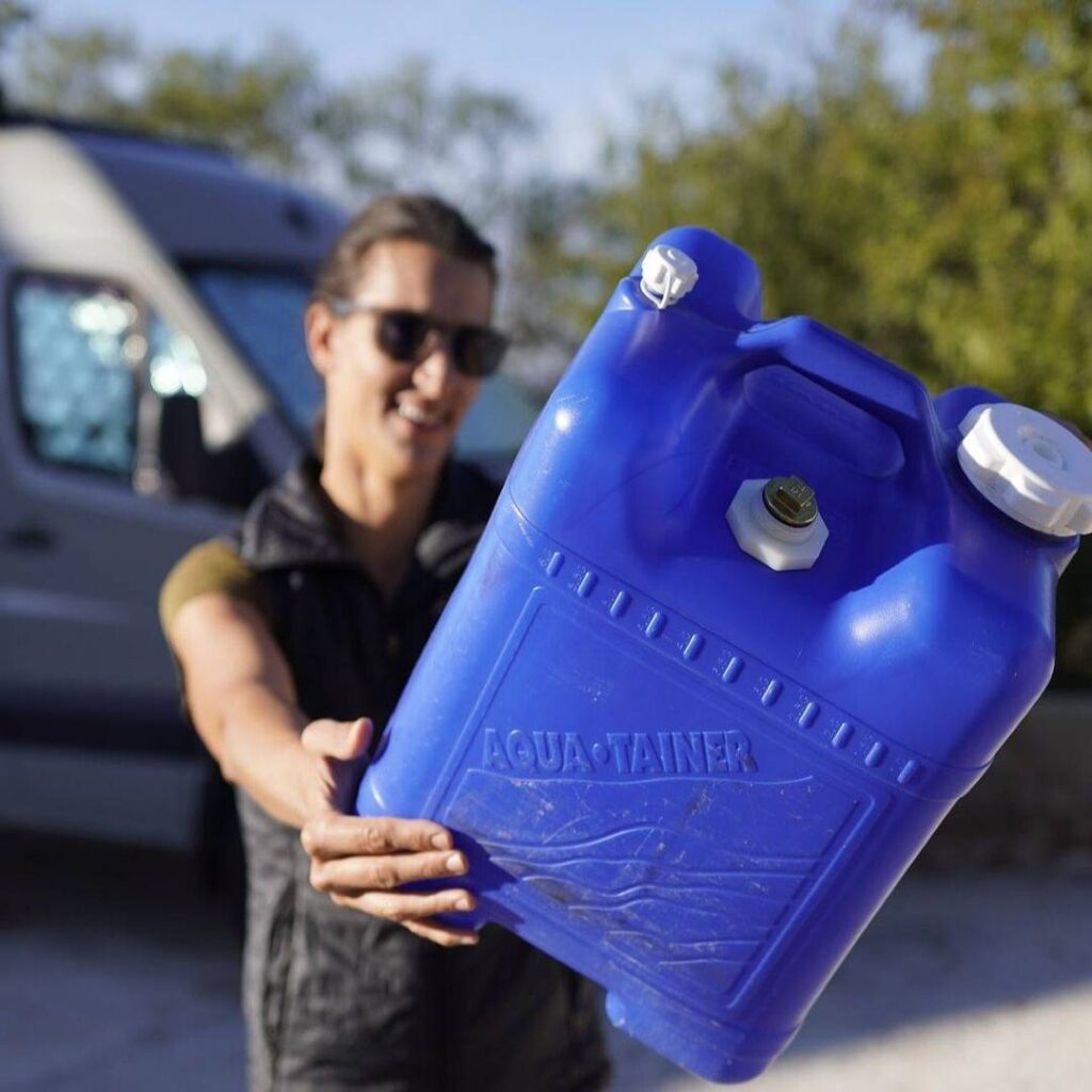 @freely.roaming Woman showing a blue water jug to the camera