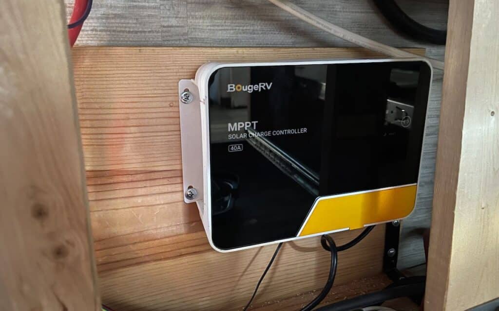 charge controller mounted on a mounting block underneath an rv kitchenette