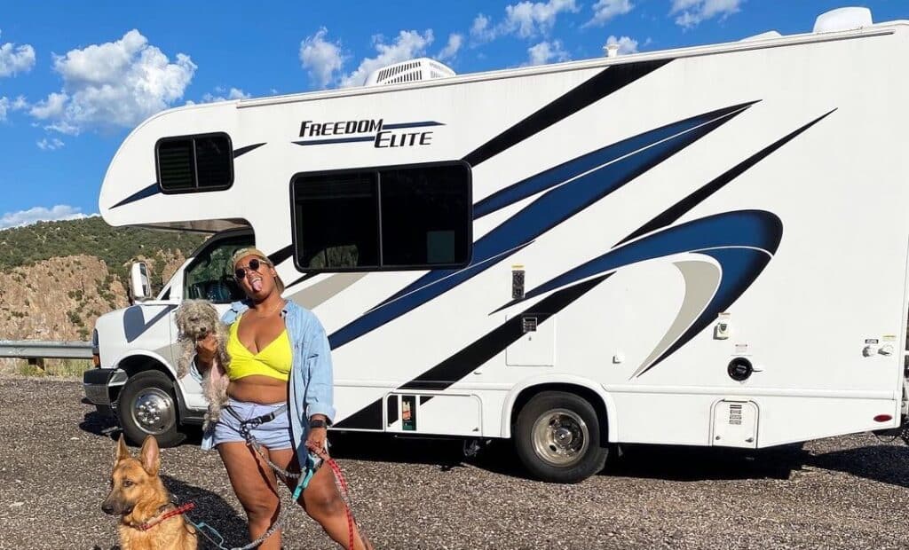 jupiter from @doesthiscountasvanlife with their dogs in front of their rv