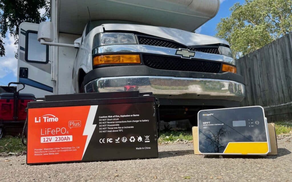 battery and charge controller on the ground in front of a class c rv