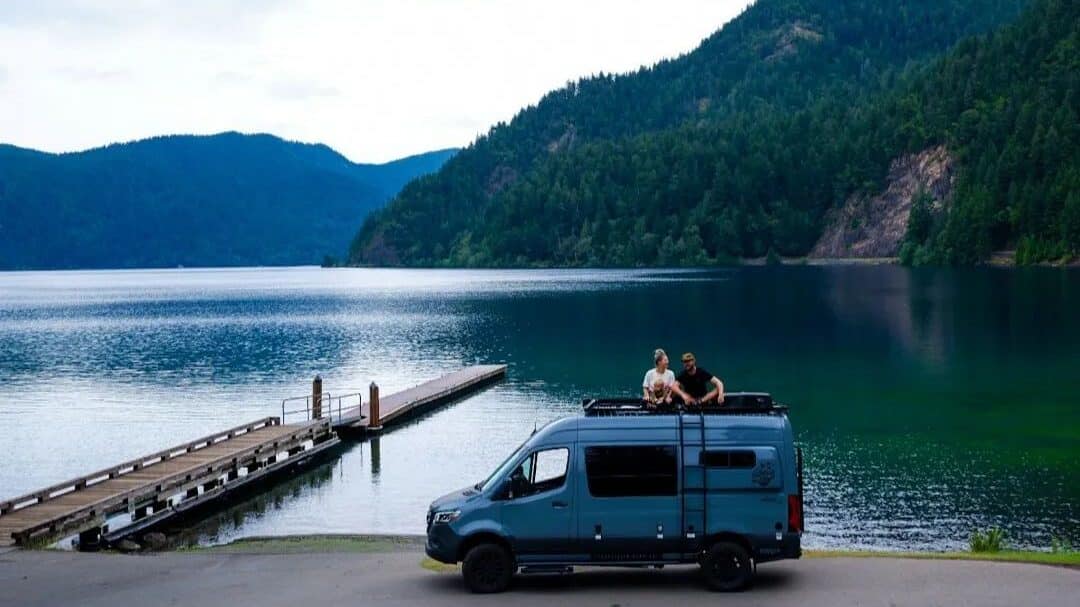 @bendadventurevans A family of three camping near lake in a storyteller overland camper from Bend Adventure Vans