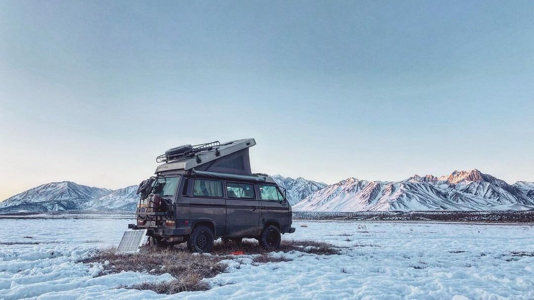 @blackforestwestfalias vw westy camper parked in a snowy desert with mountains nearby