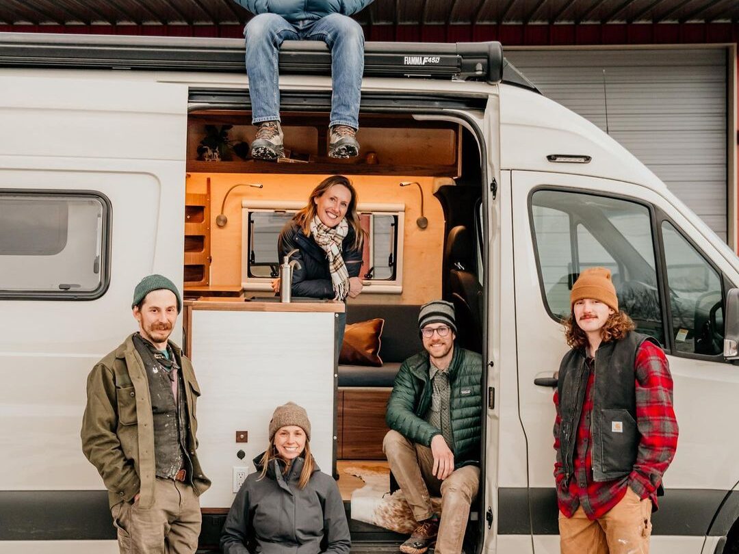 @tierratravelervans six people posing for a photo in a Sprinter camper van from Tierra Traveler
